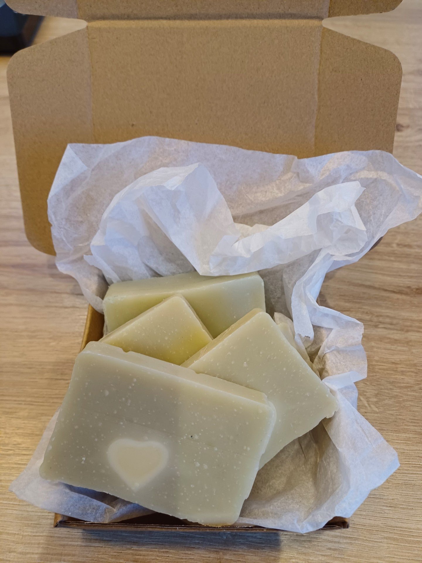 A box of Mama's mint soap crusts with one bar visible, cut into mini slices, placed on white tissue within the open box.