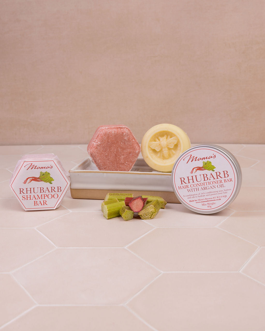 Rhubarb conditioner bar on soap dish with Rhubarb shampoo bar and pieces of rhubarb