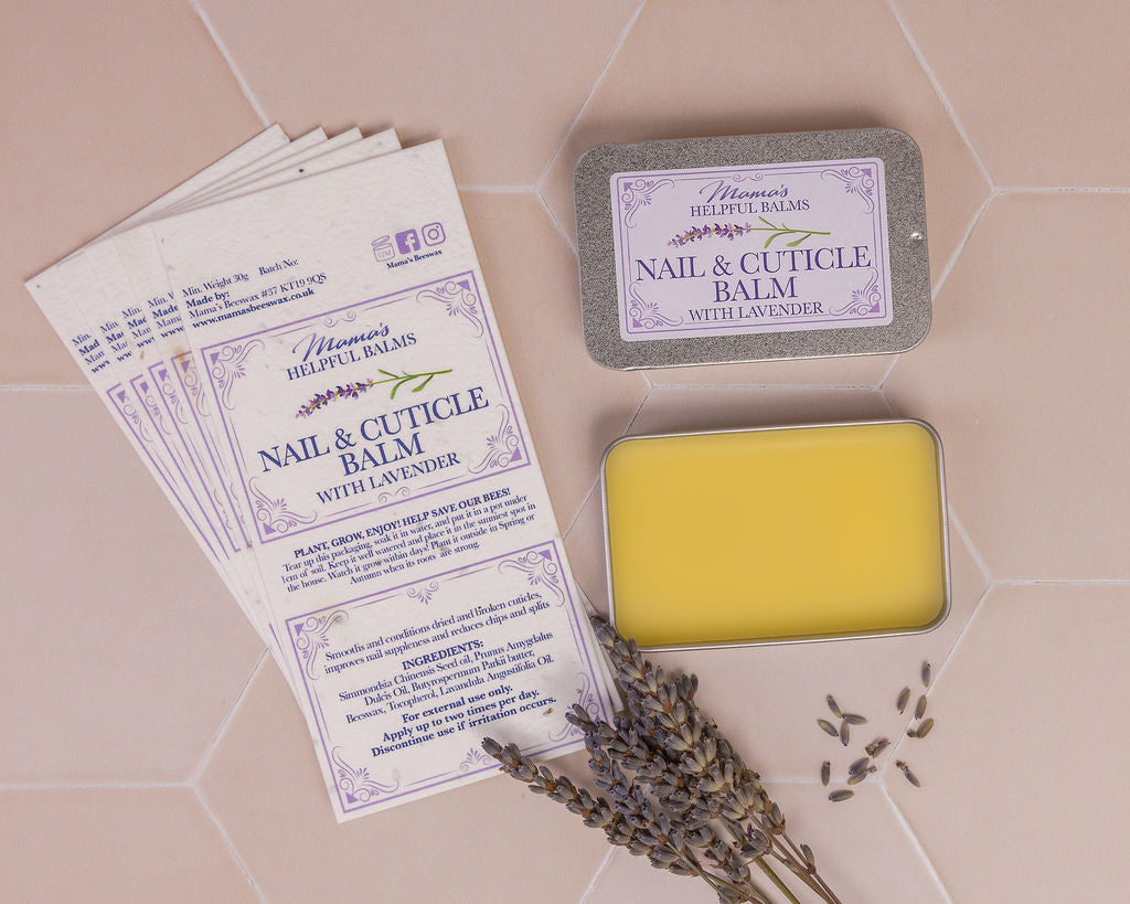 Tin of Mama's nail and cuticle balm displayed with lavender flower heads and seeded paper labels on a tiles background