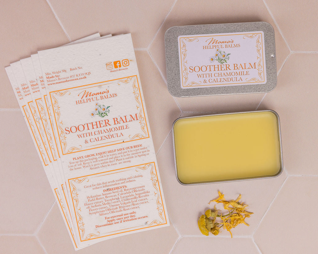 mama's soother balm displayed with calendula and chamomile petals and seeded paper labels