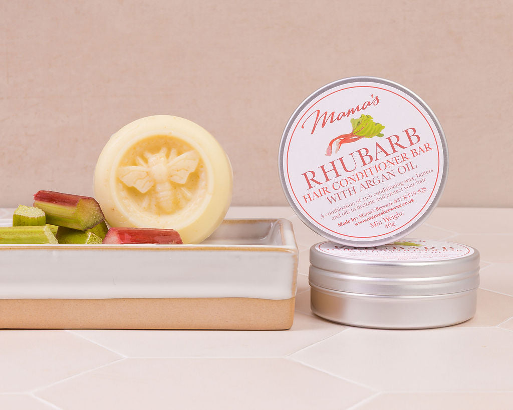Rhubarb conditioner bar  on a ceramic soap dish with pieces of rhubarb