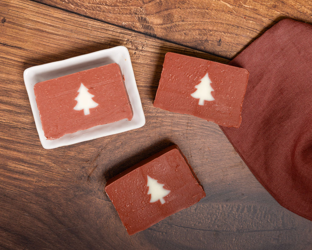Handmade Mulled Wine Christmas Soap with white tree design on a wooden board