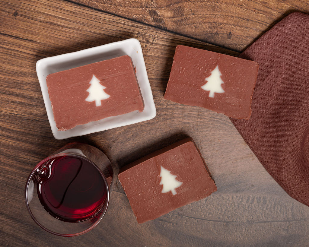 Handmade Mulled Wine Christmas Soap with white tree design, with a glass of red mulled wine.